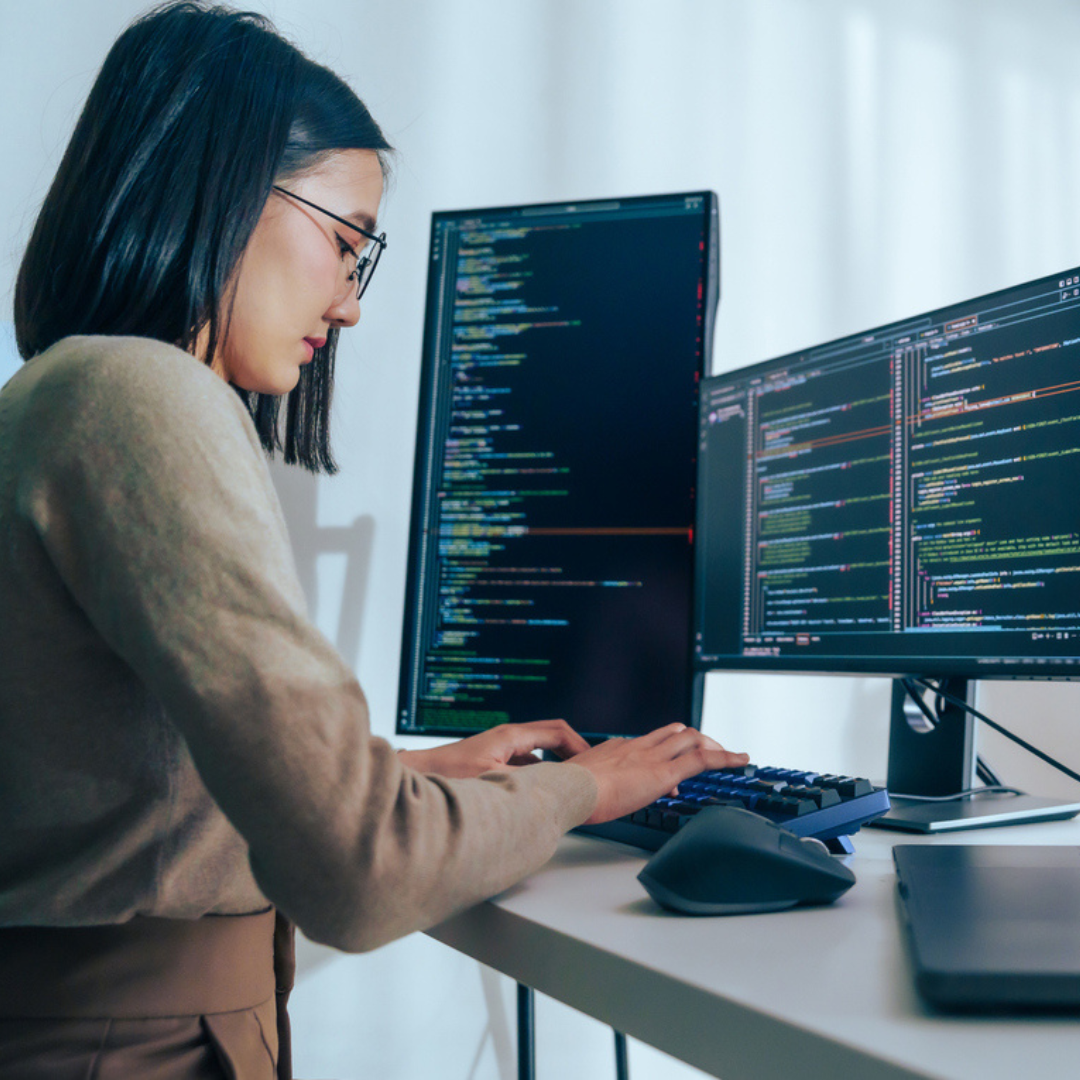 Person working with computers, highlighting DeGroote’s launch of AI‑driven graduate programs.