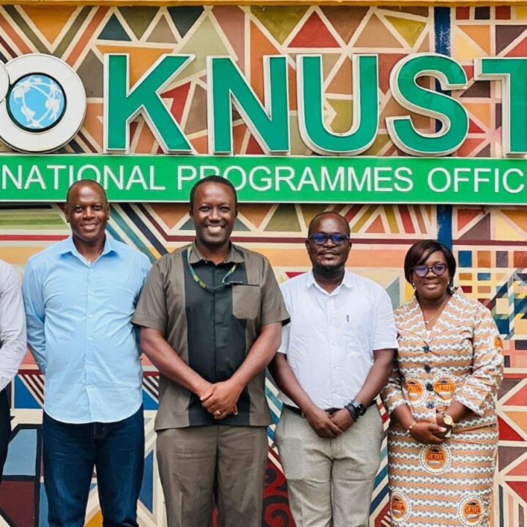 Group standing in front of the KNUST International Programmes Office sign, highlighting McMaster’s strategic engagement in Ghana led by Dr. Zoogah.