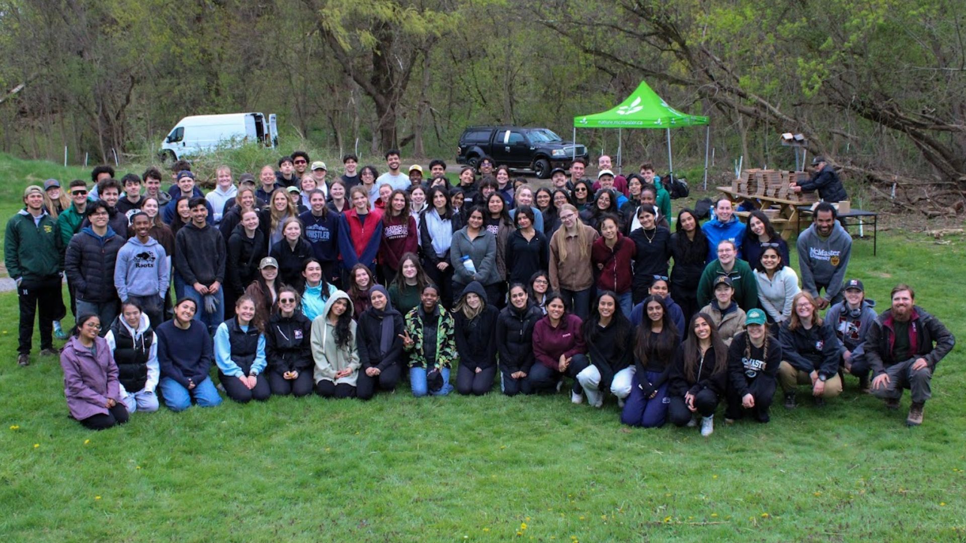 Large group posing outdoors at a park event.