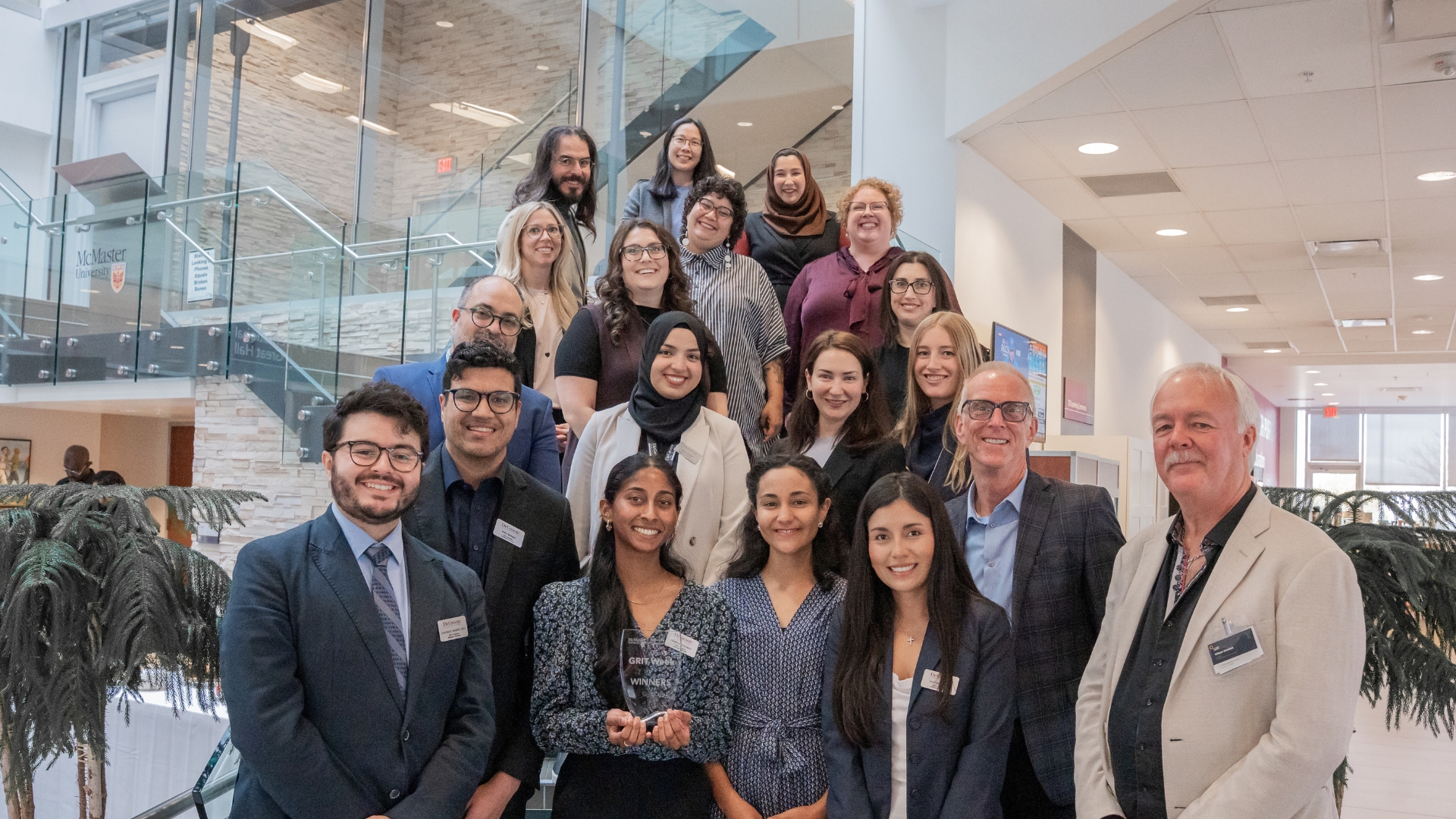 Large group posing on indoor staircase at an event.