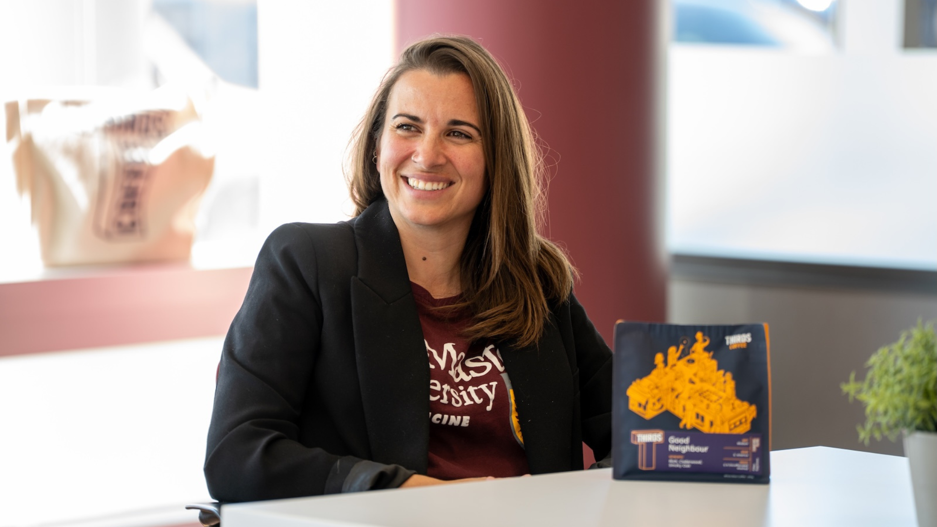 Person in blazer sitting with a McMaster award box.